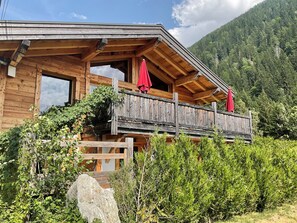 A wooden cabin with a balcony, surrounded by greenery and a mountain backdrop. - Chalet in the mountains with magnificent views of Mont Blanc (Chamonix-Mont-Blanc)