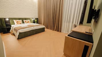 Quarto moderno com uma cama grande, uma escrivaninha de madeira e uma parede de tijolos.