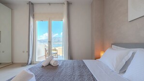 A hotel room with a bed, a view of the sea, and a balcony with a chair. - Villa Nero -
A beautiful 2-bedroom villa with Mini Pool, 5 min from the beach! (PLAKIAS)