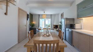 A modern kitchen with a dining area, featuring a wooden table, chairs, and a central island. - Villa Nero -
A beautiful 2-bedroom villa with Mini Pool, 5 min from the beach! (PLAKIAS)