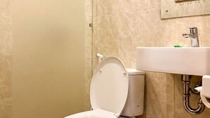 A bathroom with a toilet, a shower, and a sink. - Anugrah Twin Ubud (Ubud)