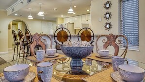 A dining area with a glass table, patterned bowls, and chairs with ornate backs. - Golf Course Views • Fireplace • Free DOLLYwood Ticket • Near Dollywood (Pigeon Forge)