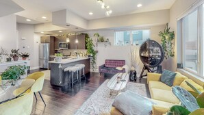 A modern living space with a kitchen, dining area, and seating area.