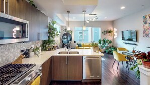 A modern kitchen with a central island, stainless steel appliances, and wooden cabinets.