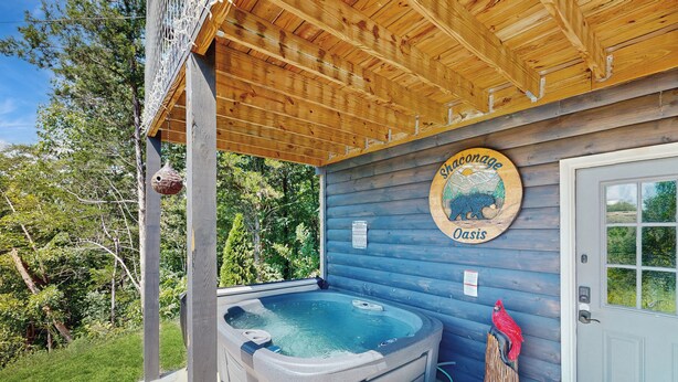 Una cabaña de madera con un jacuzzi, una puerta de madera y un letrero que dice "shaconage Oasis".