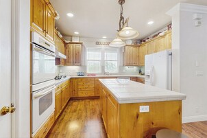 A kitchen with wooden cabinets, a white countertop, and a built-in oven.