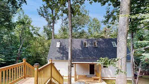 Ein Haus mit einer Holzdiele, einer überdachten Veranda und einem kleinen Vorgarten.