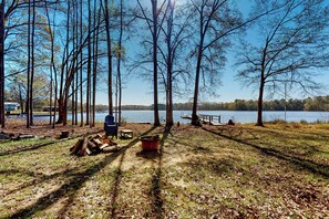 En park vid sjön med ett trädäck, bänkar och ett picknickbord.