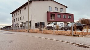 Un immeuble à plusieurs étages, doté d’un toit plat et présentant une variété de styles de fenêtres.