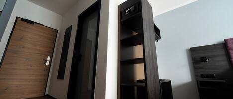 A modern room with a wooden door, a built-in shelf unit, and a small table.