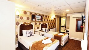 A hotel room with two beds, a desk, a mirror, and a bathroom visible through an open door. - ELYSİON HOTEL (İstanbul)