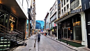 A narrow urban street with shops and the Elysion Hotel. - ELYSİON HOTEL (İstanbul)