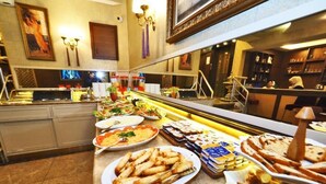 A buffet with various dishes, including bread, salads, and other prepared foods. - ELYSİON HOTEL (İstanbul)
