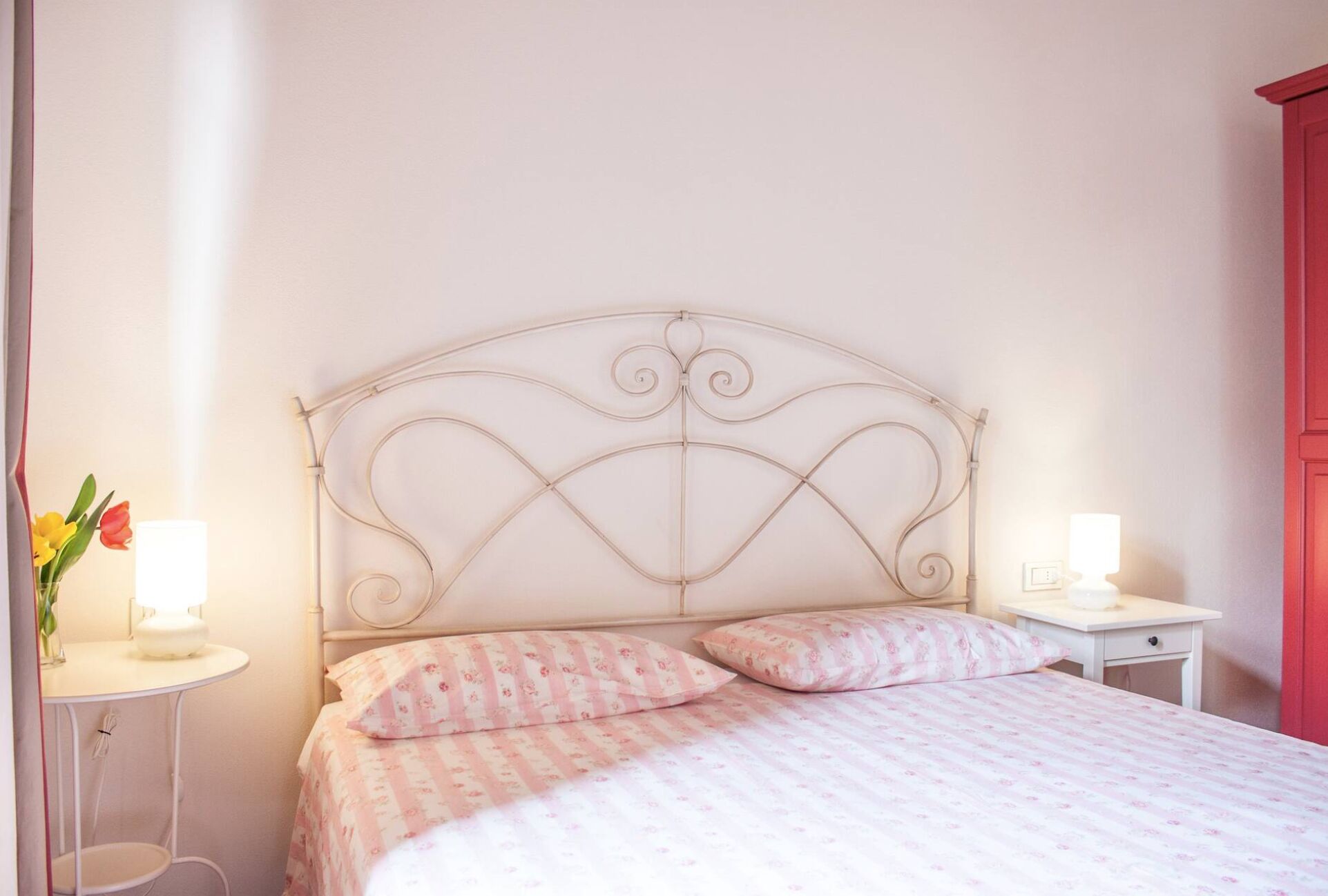 A bedroom with a bed, two bedside tables, and a nightstand.
