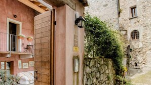 A narrow cobblestone alley with a rustic building featuring a wooden door and a stone wall. - Alla torre del barbarossa B&B Foresteria (Maggiana)