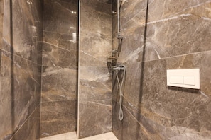 Une salle de bain moderne avec des murs en marbre et un espace douche.