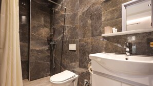 A modern bathroom with a glass-enclosed shower, a white toilet, and a sink with a mirror above it. - Azzurra Studio 02 in Durr s (Durrës)