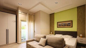 A bedroom with a sofa, a bed, a nightstand, and a framed picture on the wall. - Azzurra Studio 01 in Durr s (Durrës)