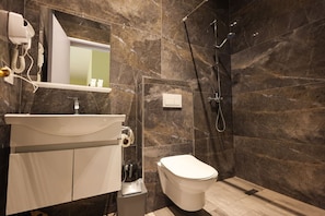 A modern bathroom with a marble wall, a white sink, a toilet, and a shower area. - Azzurra Studio 03 in Durr s (Durrës)