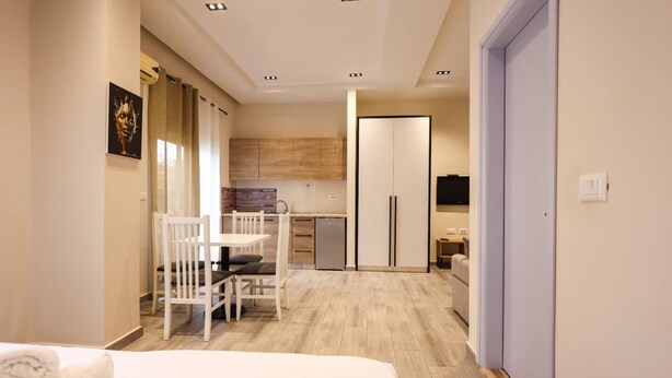 Ein modernes Hotelzimmer mit Bett, Esstisch und einer Küchenzeile.