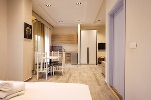 A modern hotel room with a bed, a small dining table, and a kitchenette. - Azzurra Studio 05 in Durr s (Durrës)