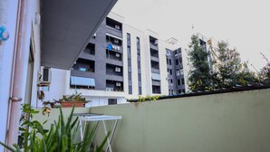 Ein modernes Mehrfamilienhaus mit Balkonen, einige mit Pflanzen und Wäsche.