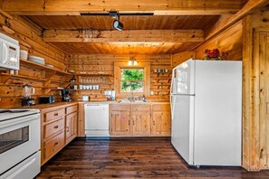 A wooden cabin kitchen with a refrigerator, stove, and wooden cabinets. - 3BR Resort Cabin w/Views! Hot Tub*Games*Comm Pool (Sevierville)