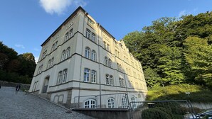 A multi-story building with a symmetrical facade, large windows, and a stone base. - Apartment at the Saxon Switzerland National Park (Sebnitz)