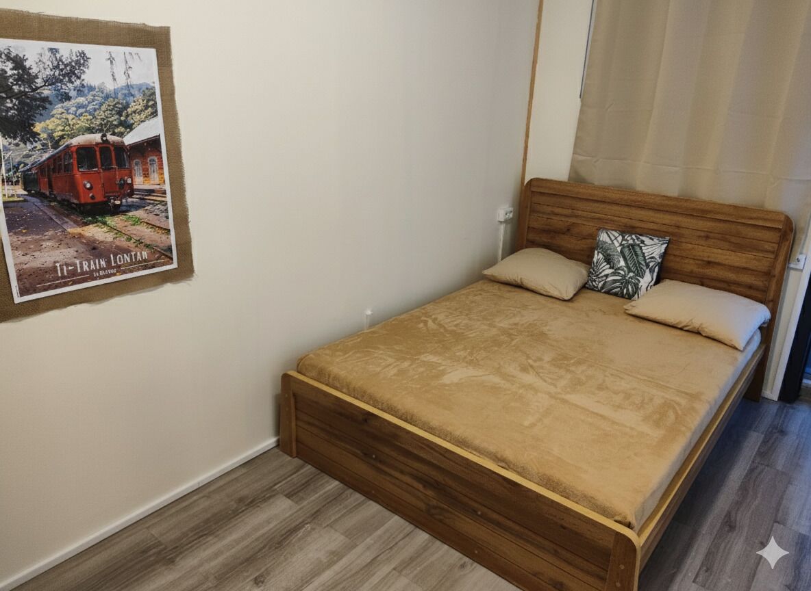 A bedroom with a wooden bed, a poster on the wall, and a window with curtains.