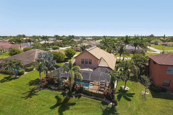 A residential area with houses, a swimming pool, and well-maintained lawns. - Experience the Florida dream at Villa Barbara in Cape Coral! (Cape Coral)