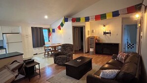 Una sala de estar amplia con ventilador de techo, chimenea y comedor con mesa y sillas.