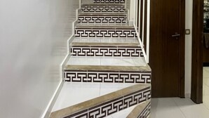 Una scala con un motivo geometrico sui gradini e una porta in legno alla base.