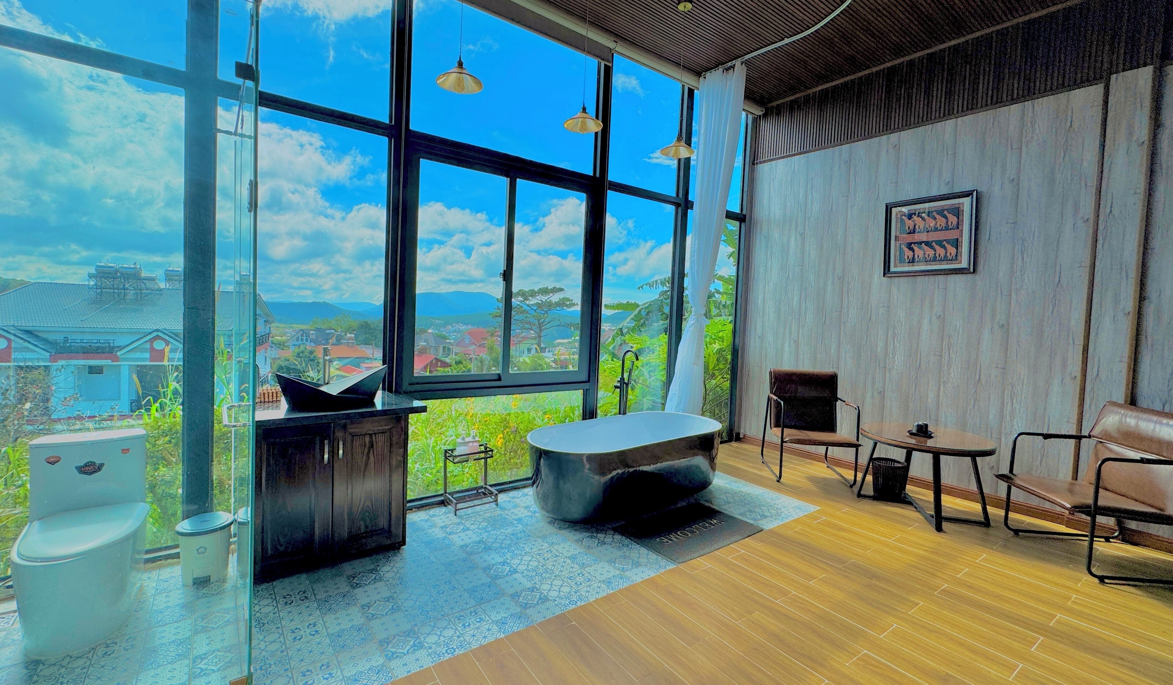 A modern bathroom with a large window, a bathtub, a toilet, and a sink.