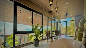A spacious room with large windows, a modern bathtub, and a potted plant. - Khu Vuon Cua Nang Le Jardin De Nang (Cam Ly - Da Lat)