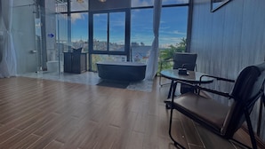 A modern bathroom with a large window, a bathtub, and a shower area. - Khu Vuon Cua Nang Le Jardin De Nang (Cam Ly - Da Lat)