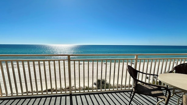 Ein Balkon mit Blick auf Strand und Meer.