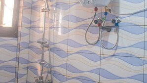 A bathroom with a water heater, a shower, and a tiled wall with a wavy pattern. - Secure apartment in the heart of yaounde 10m from the tarmac (Yaoundé)