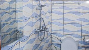 A bathroom with a shower, toilet, and sink, all with a wavy tile pattern.