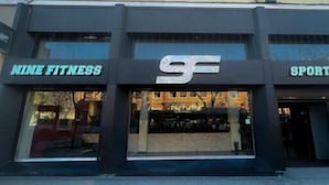 A building with a sign that reads "NINE FITNESS" and another sign that reads "SPORTS". - Fit Hostel Madrid (Madrid)