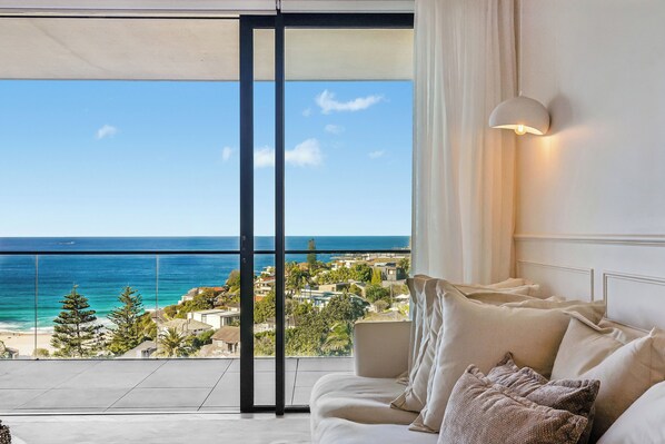 A balcony with a view of the ocean and a coastal town. - Three-Bedroom Ocean-View (Tamarama)
