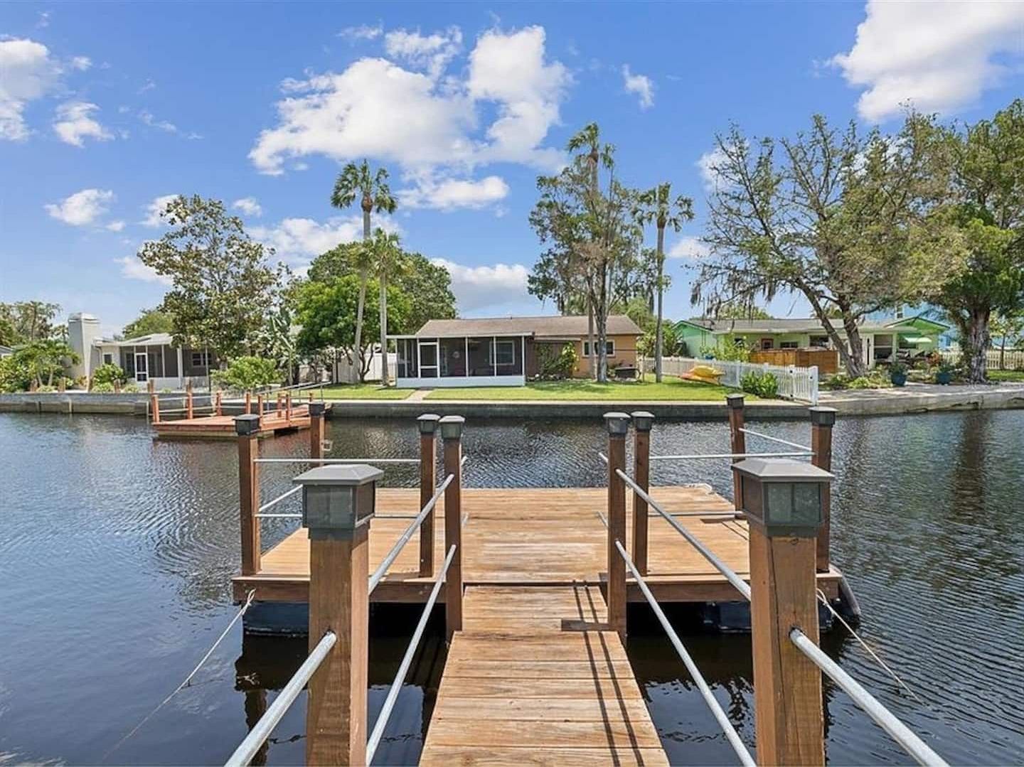 Wooden dock on the river with water views and neighboring homes