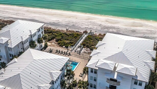 A beachfront hotel with multiple buildings, a pool, and a beach view.
