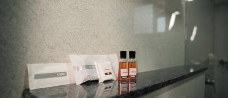 En badeværelsesbordplade med toiletartikler, herunder kamme, shampoo og balsam.