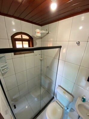 Een douche, handdoeken, zeep, toiletpapier