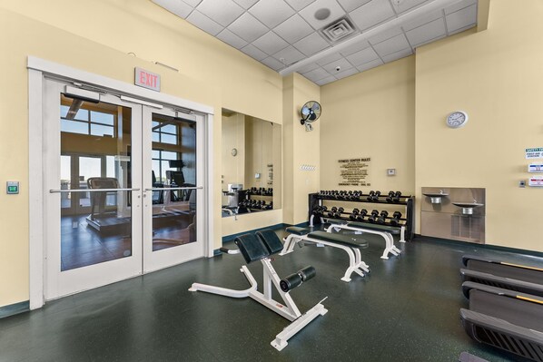 A fitness center with exercise equipment, a clock, and an emergency phone. - Penthouse Premium 3BR Condo - 1900+ Sq Ft - Beach Service Included (Panama City Beach)