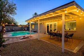 A covered outdoor patio with a pool, lounge chairs, and a dining area. - Stylish Phoenix home | Private pool | Spacious living | Family & sports-friendly | Close to Phoenix Zoo, Desert Botanical Garden, ASU, and State Farm Stadium (Phoenix)