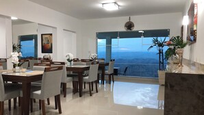 A modern dining area with a view of the mountains. - Unique Alta Vista Pousada Boutique (Córrego do Bom Jesus)
