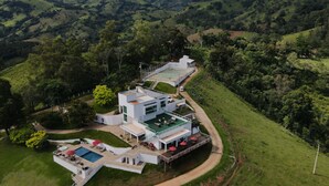 A modern house with a swimming pool, outdoor seating, and a tennis court. - Unique Alta Vista Pousada Boutique (Córrego do Bom Jesus)