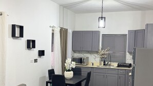 A compact living space with a kitchenette, a dining area, and a sofa.