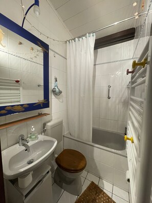 Ein Badezimmer mit Waschbecken, Toilette, Dusche und einem spiegel mit blauem Rahmen.